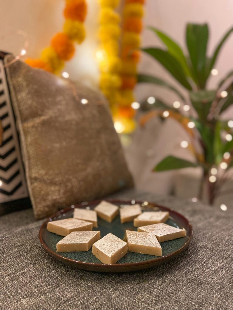 Plate of Kaju Katli sweets with festive decor in Mumbai, India.